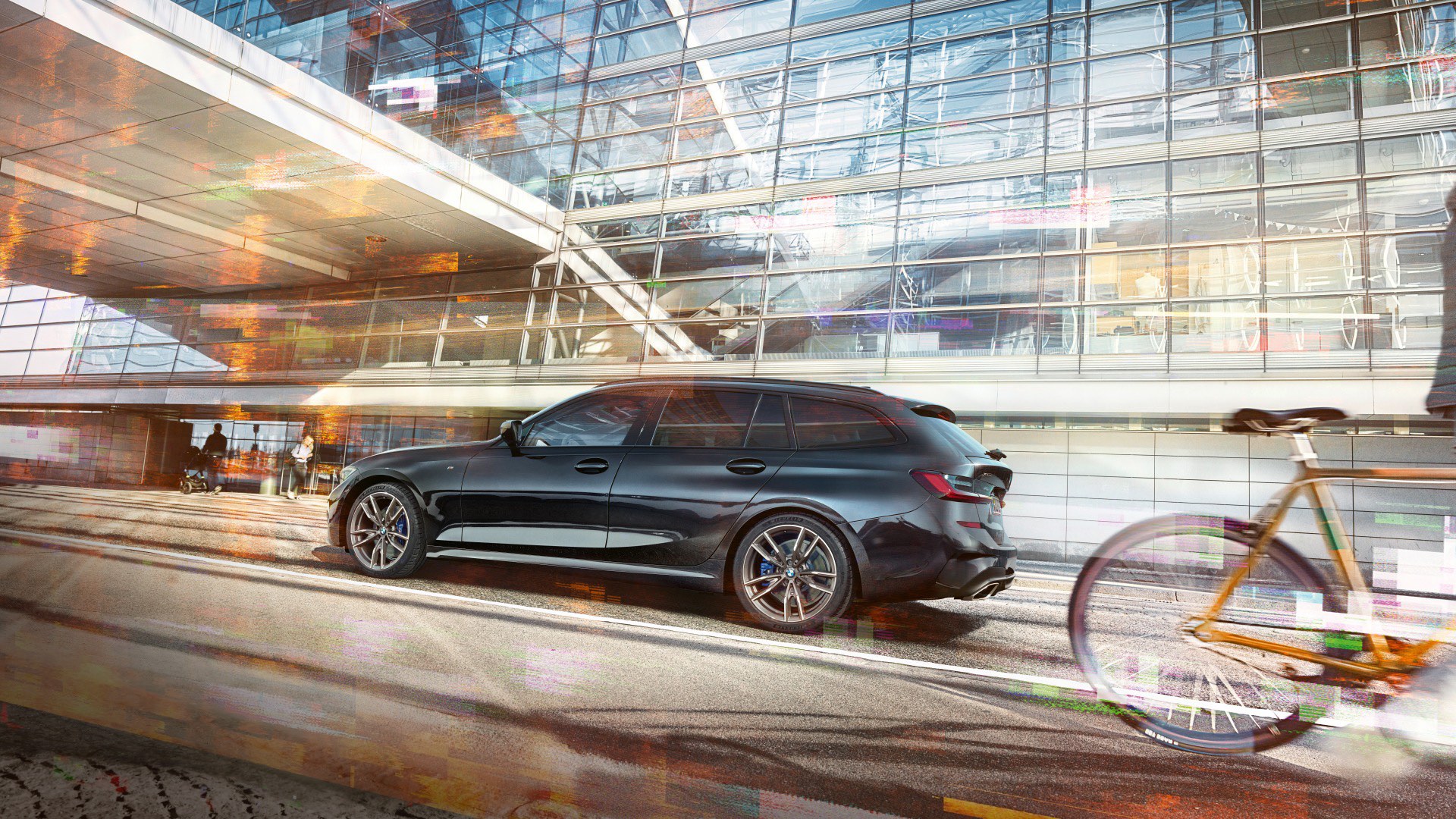 BMW M340i xDrive Touring Der BMW M340i xDrive Touring auf einer Straße vor einer Glasfassade