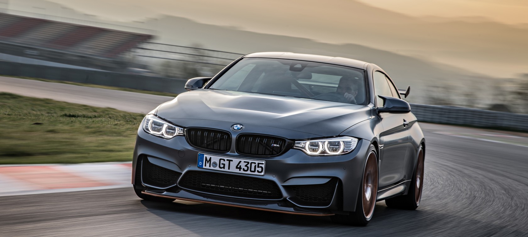 Fahrender BMW M4 GTS auf Rennstrecke mit Bergkette im Hintergrund