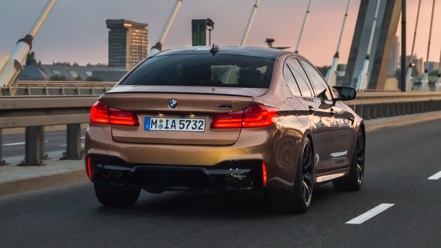 BMW M5 Competition in Zanzibar metallic fährt auf einer Brücke