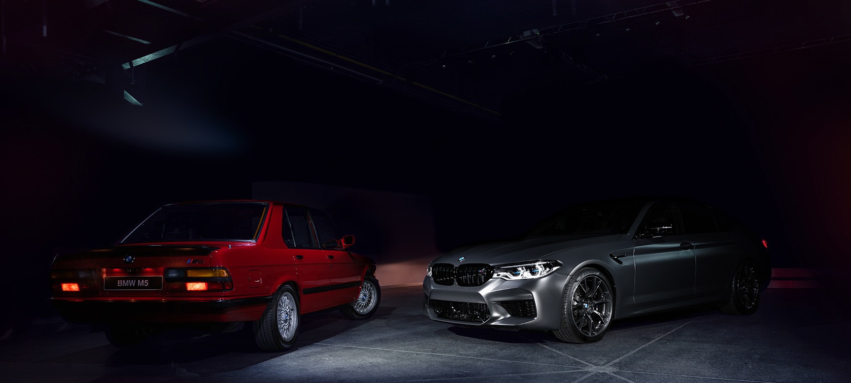 Ein BMW M5 Edition 35 Jahre und roter BMW M5 der ersten Generation stehen nebeneinander
