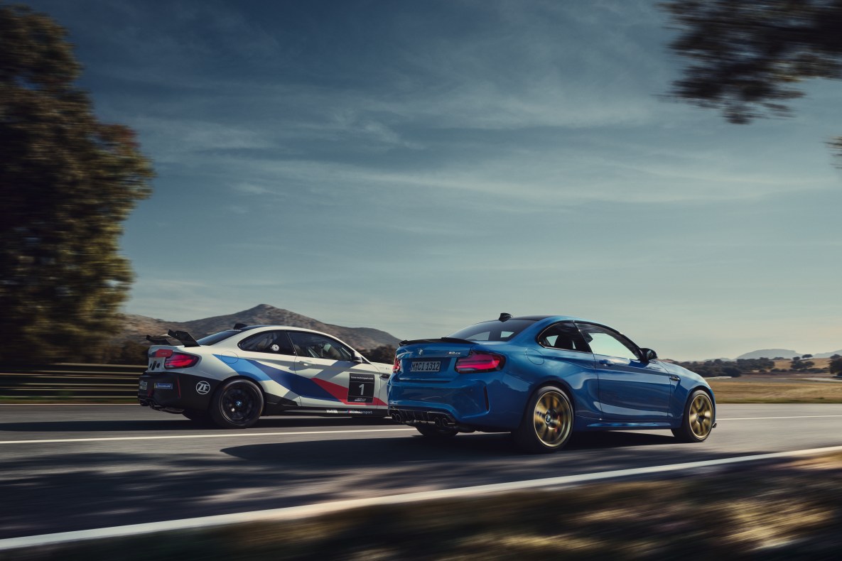 Ein BMW M2 CS Racing und ein blauer M2 CS fahren nebeneinader auf einer Rennstrecke