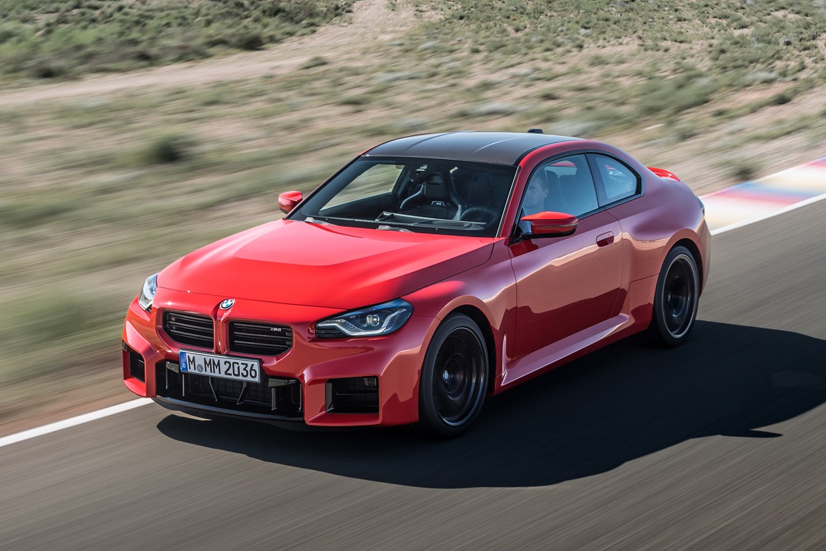 Ein roter BMW M2 im Halbprofil auf der Rennstrecke.