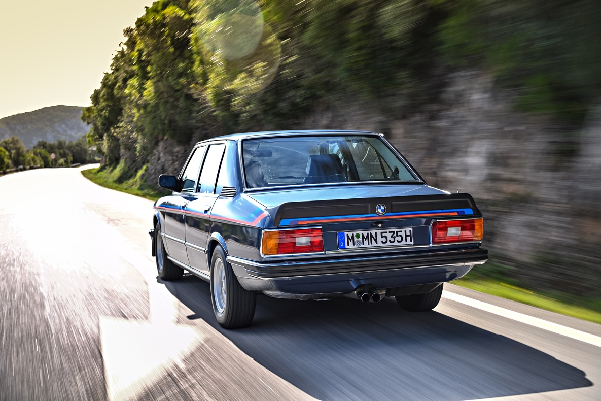 Heckansicht des BMW E12 M5435i fahrend auf der Landstraße.