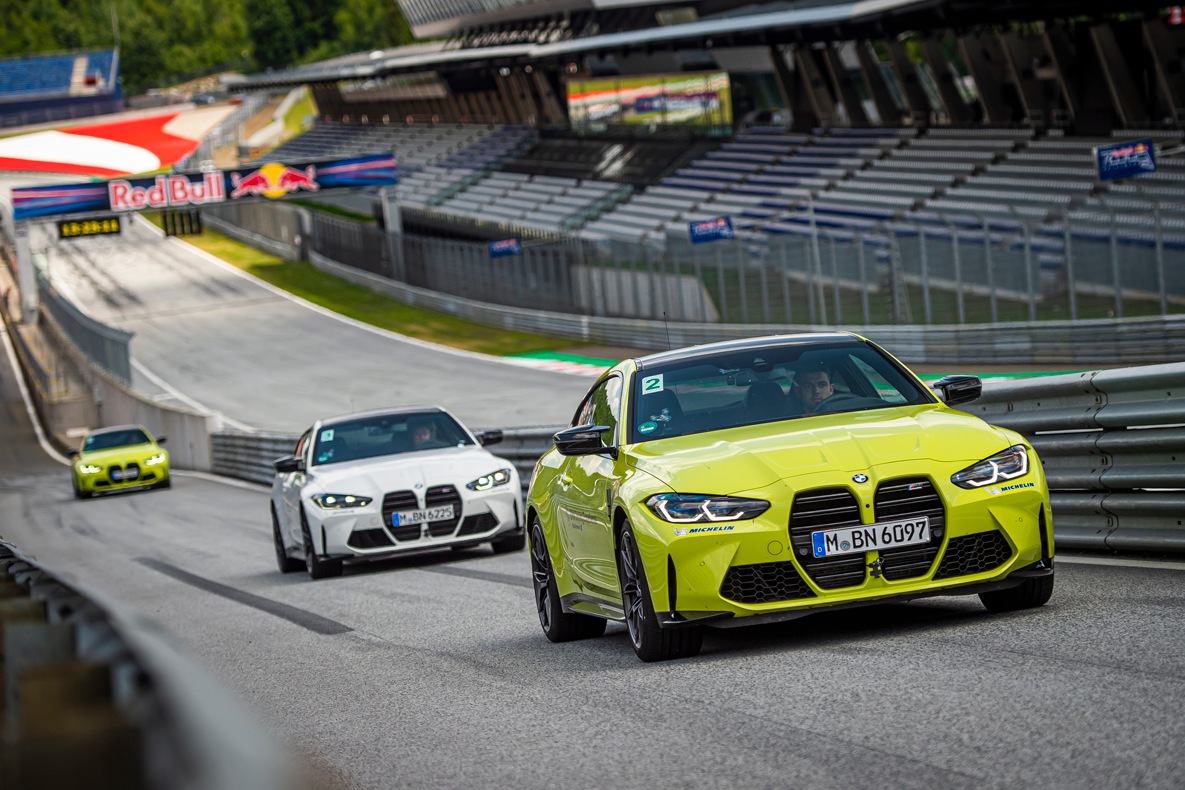 Drei BMW M4 Coupé fahren hintereinander durch die Boxengasse.