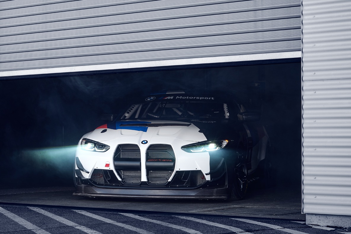BMW M4 GT4 fährt aus einer Box mit halb heruntergelassenem Tor.