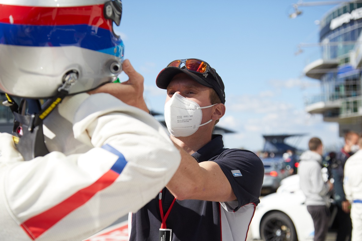 Ein Instruktor der BMW M Driving Experience hilft beim Anziehen des Helms auf einem BMW M Trackday.