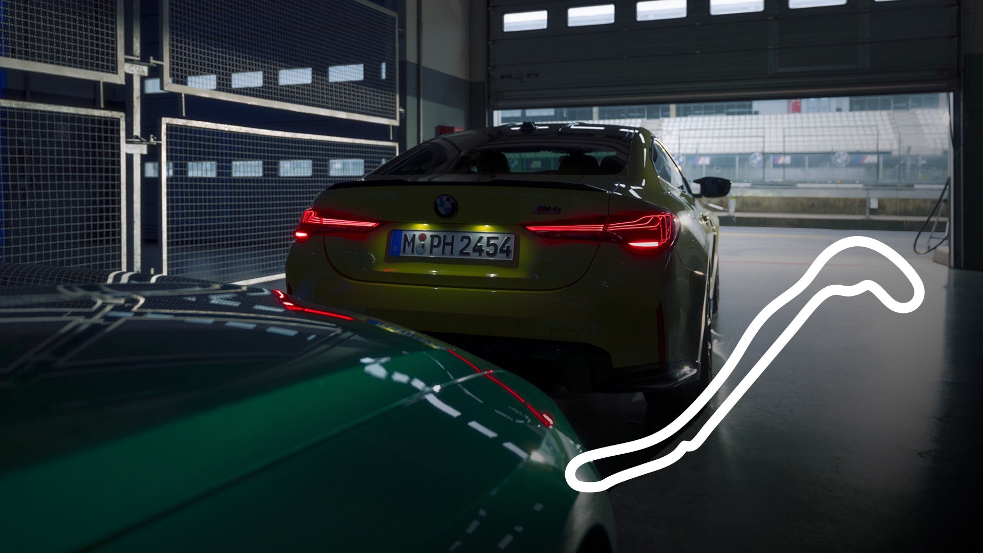 Ein gelber BMW M4 mit beleuchteten roten Rücklichtern in einer Garage geparkt, wobei eine Rennstrecke durch das offene Tor sichtbar ist. Im Vordergrund ist teilweise ein grünes Fahrzeug zu sehen, und in der unteren rechten Ecke wird eine weiße Grafik des Streckenlayouts angezeigt.