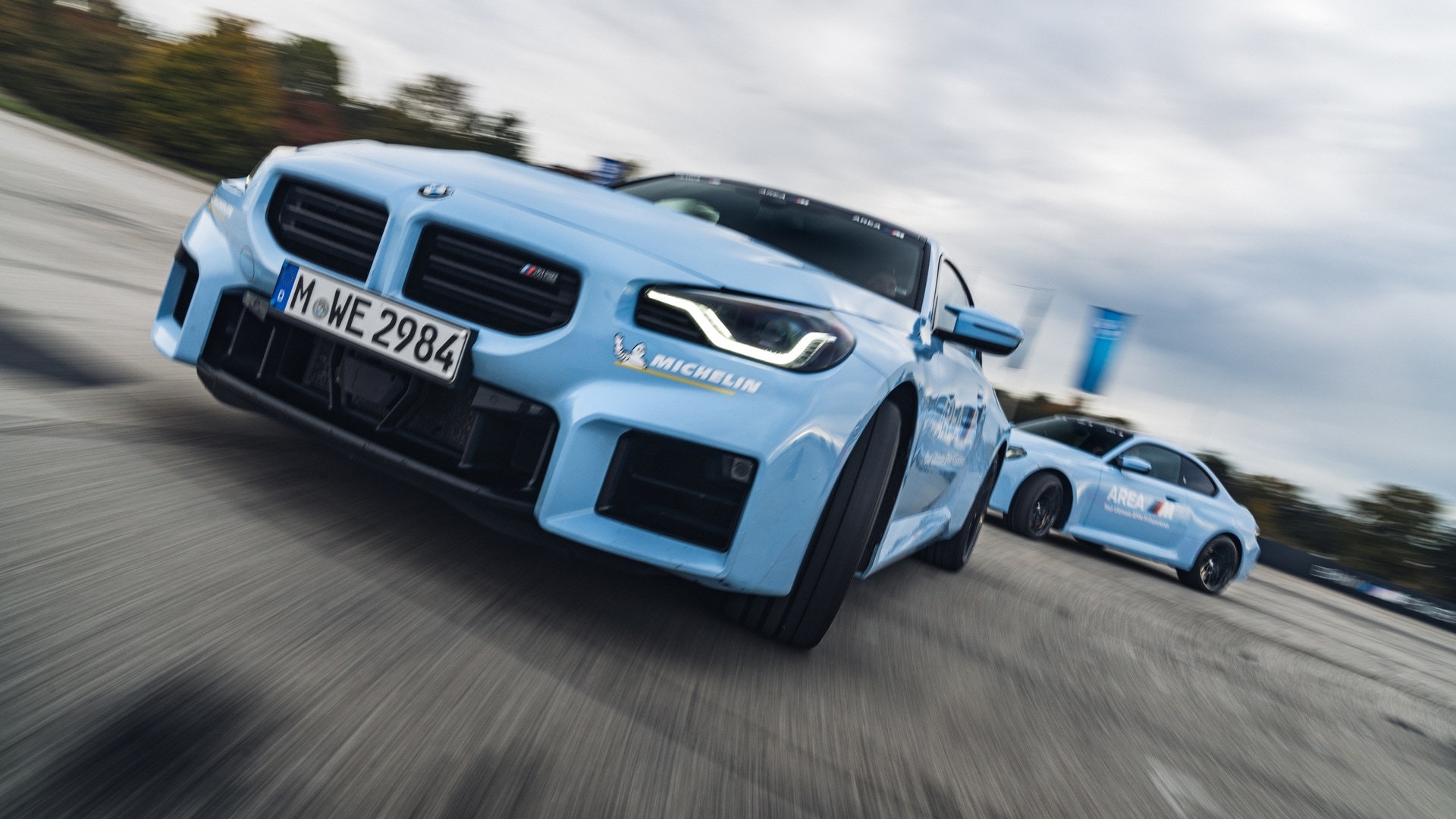 BMW M2 light blue AREA M Driving Experience three quarter front view trackday action