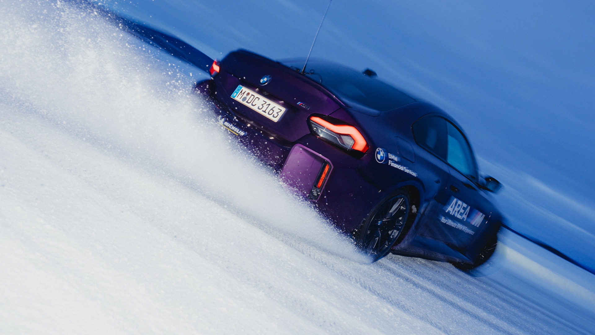 BMW M Lila in Heckansicht im Drift bergab mit AREA M und BMW Financial Services Beschriftung