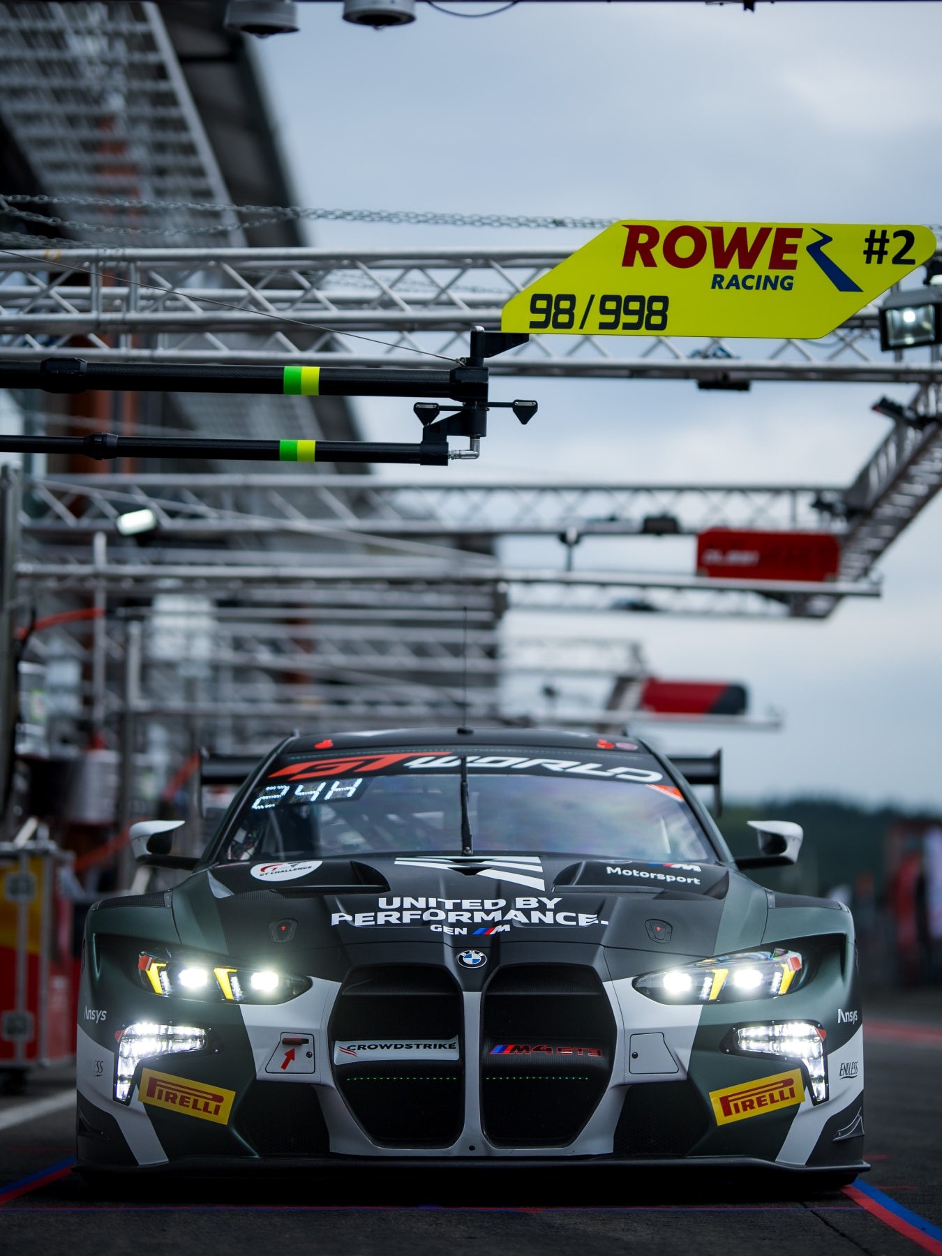 BMW M4 GT3 EVO von Rowe Racing mit der GEN-M-Livery steht in der Boxengasse