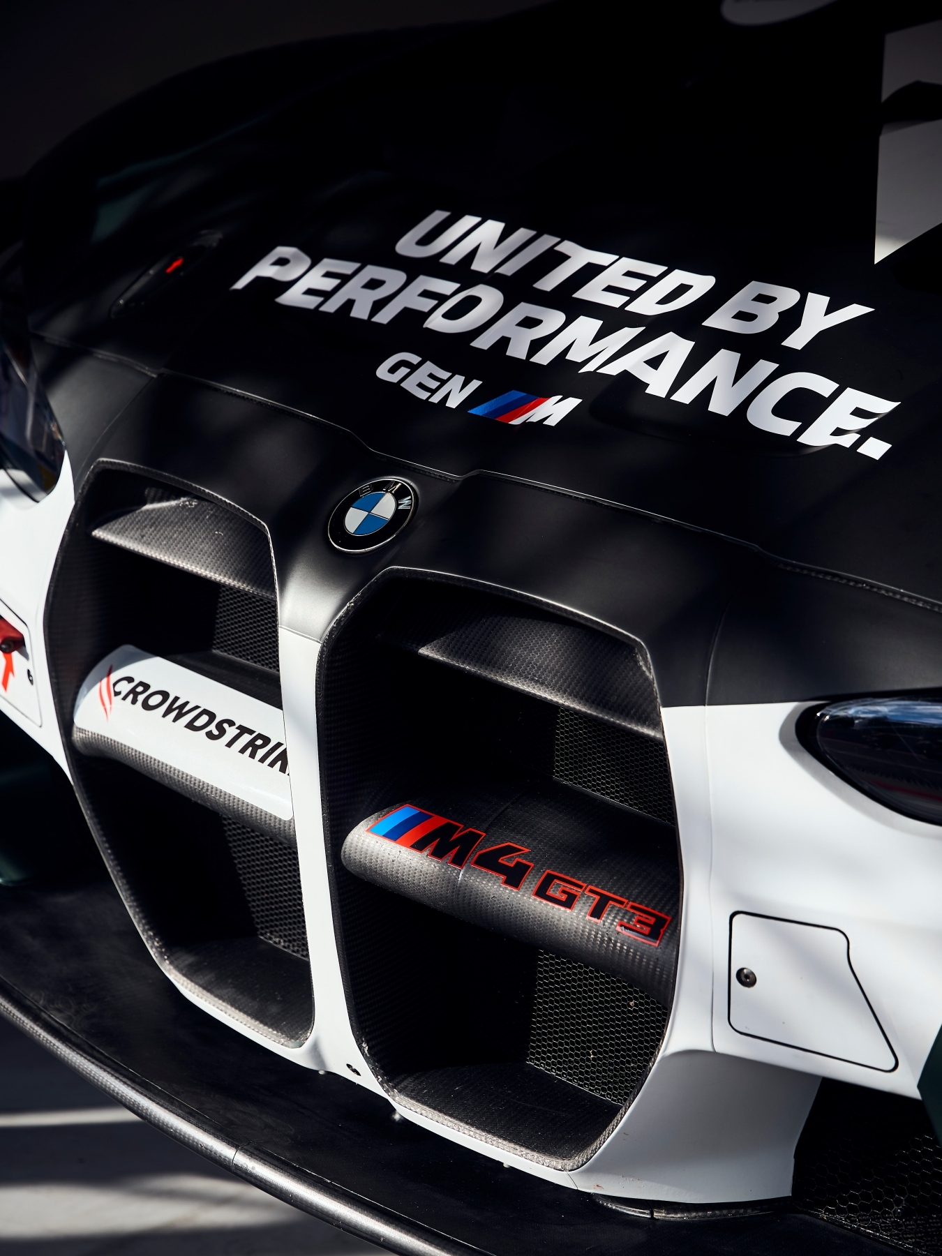 Motorhaube und Front des BMW M4 GT3 EVO von Rowe Racing mit dem "United by Performance"-Schriftzug