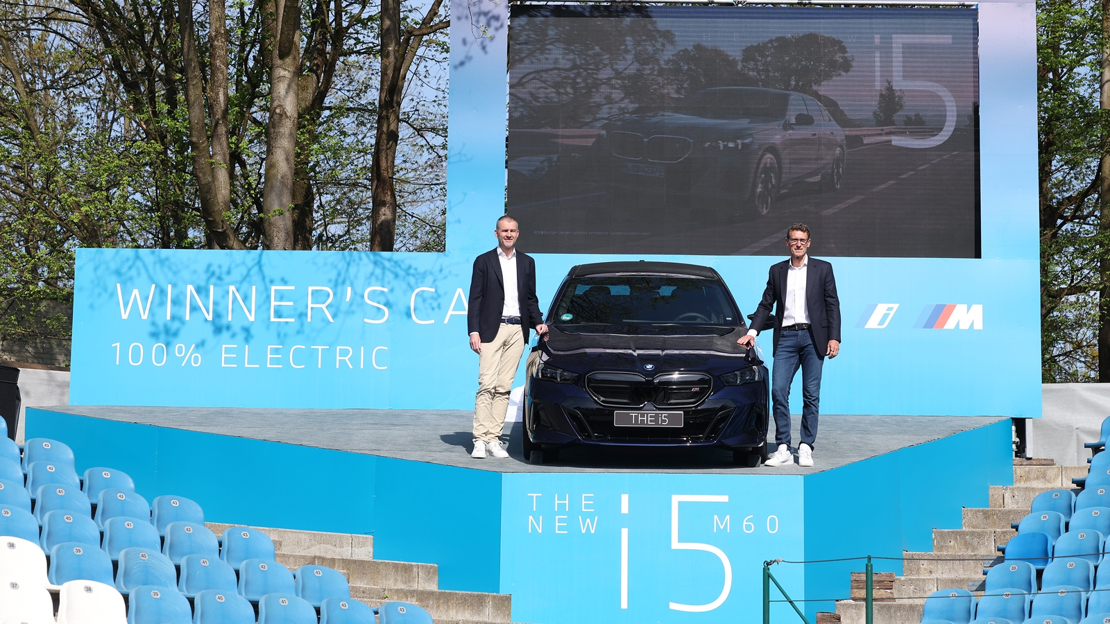 Christian Ach und Patrik Kühnen enthüllen den BMW i5 M60 auf der BMW Open.