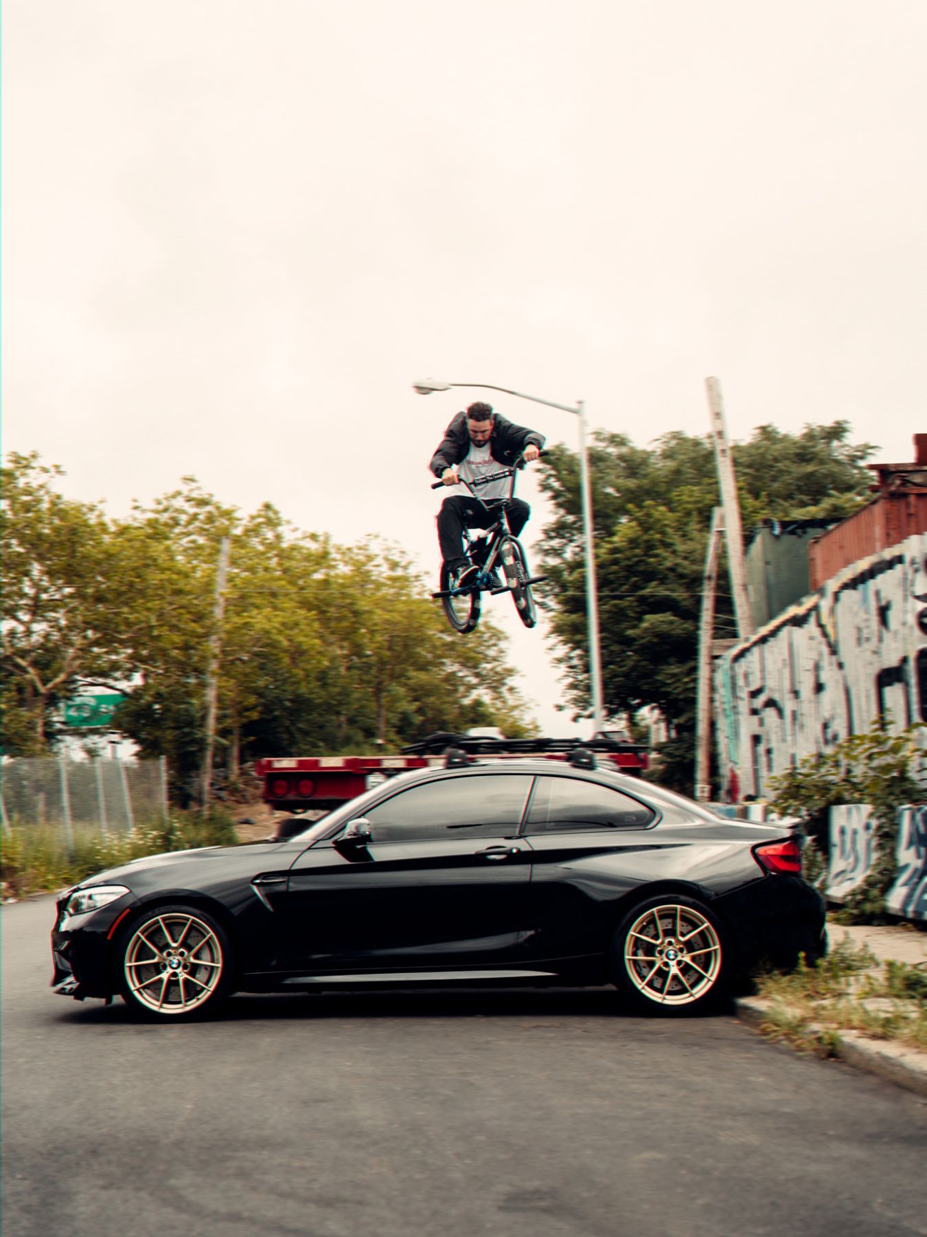 Billy Perry jumps over his BMW M2 F87