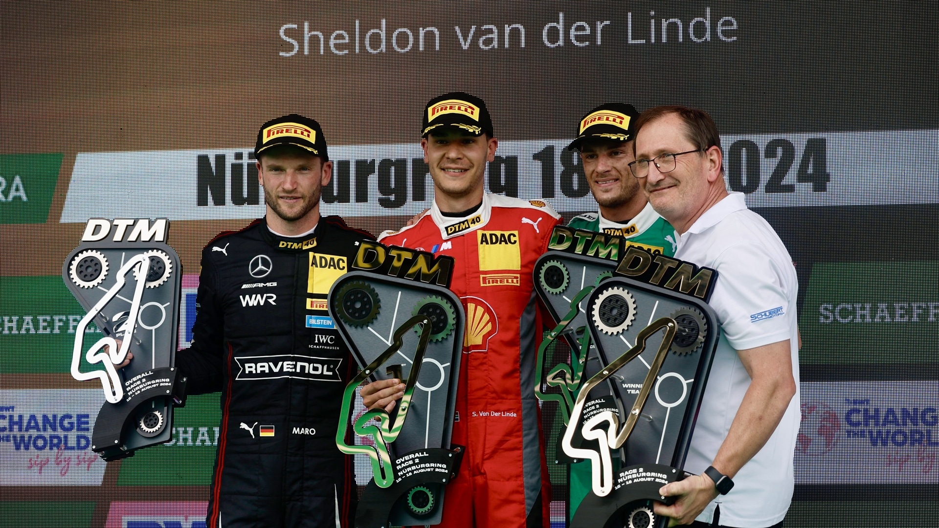 Teamchef Torsten Schubert (r.) mit BMW M Werksfahrern Sheldon van der Linde (2. v. l.) und Marco Wittmann (2. v. r.) auf dem Podium am Nürburgring, 2024.