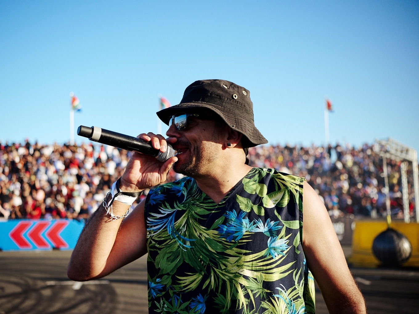 MC Vic Pardal moderiert Spinning-Event in Südafrika, während vor ihm ein BMW E30 Spinning-Figuren fährt. 