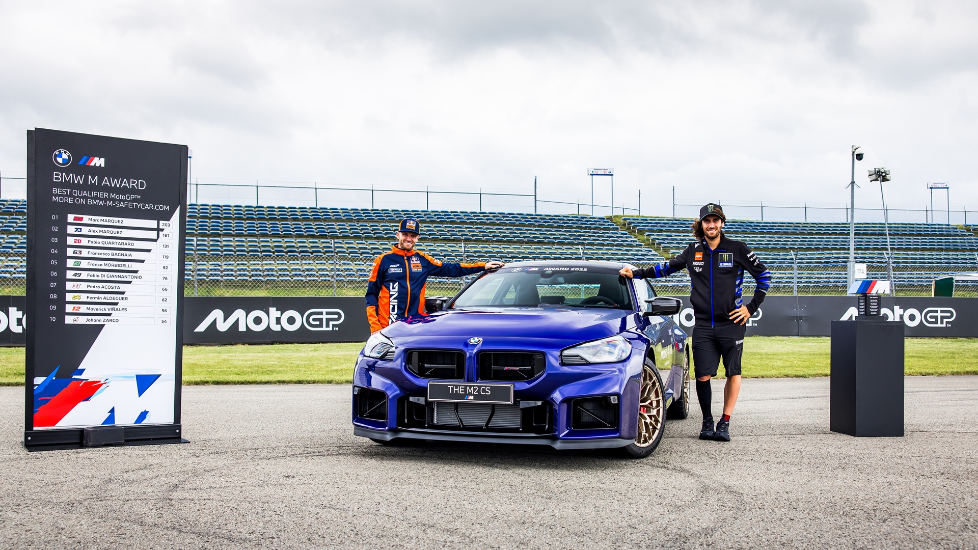 MotoGP™-Piloten Brad Binder und Álex Rins mit dem BMW M2 CS