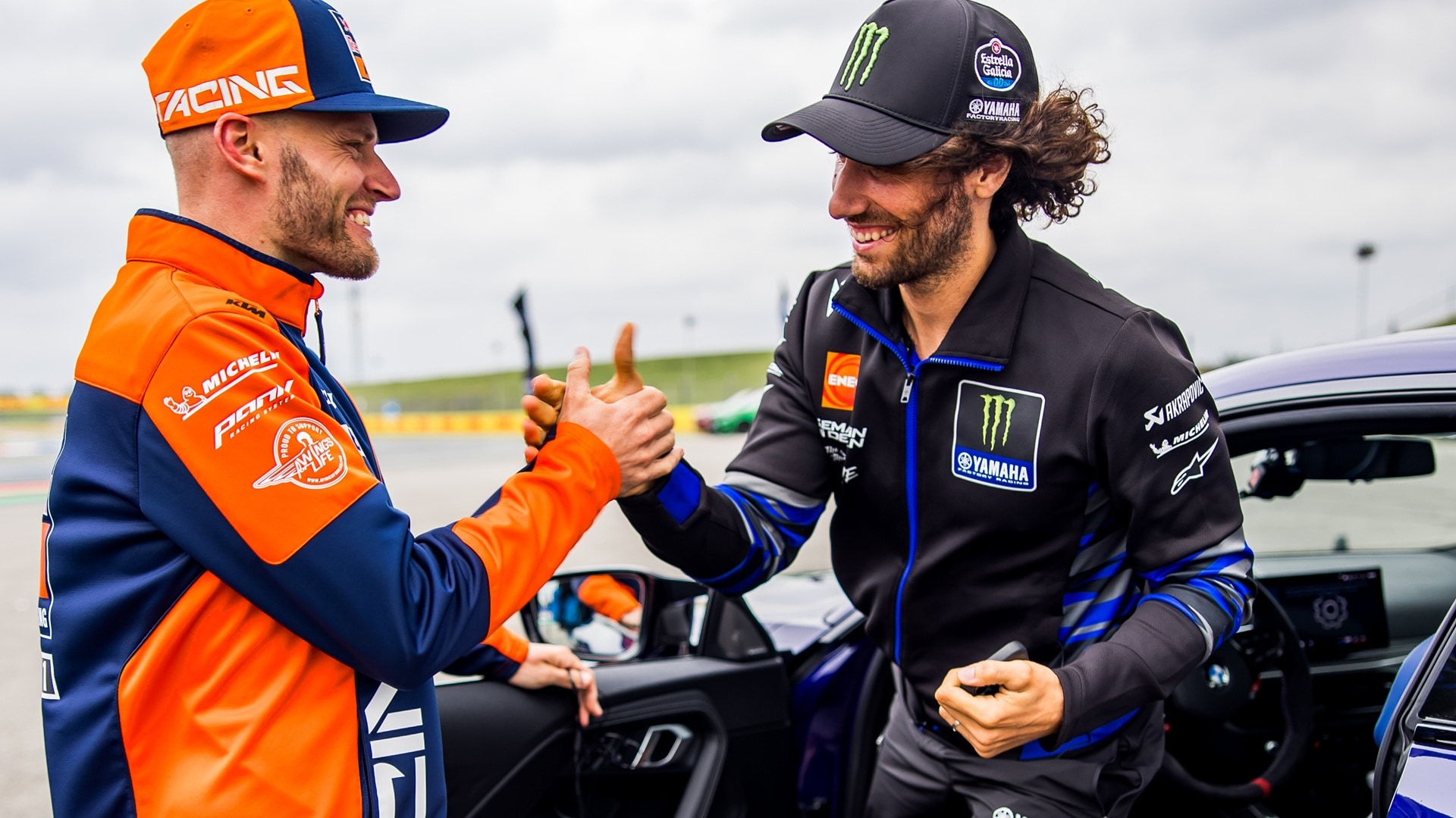 MotoGP™ riders Álex Rins and Brad Binder with an BMW M2 CS.