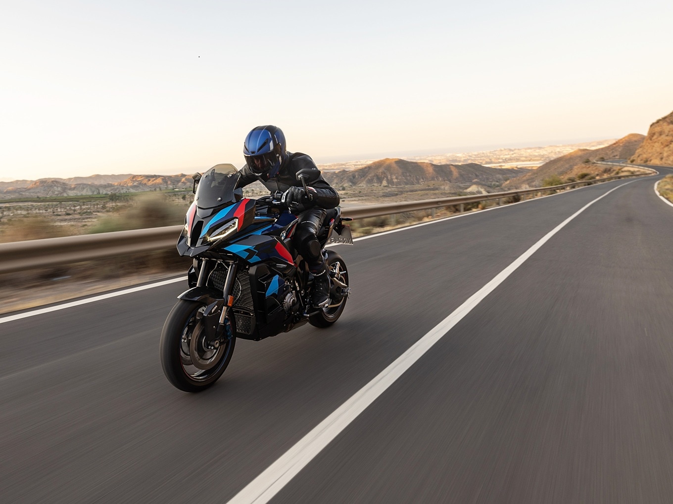 BMW M 1000 XR fährt auf langer, gerader Landstraße. 