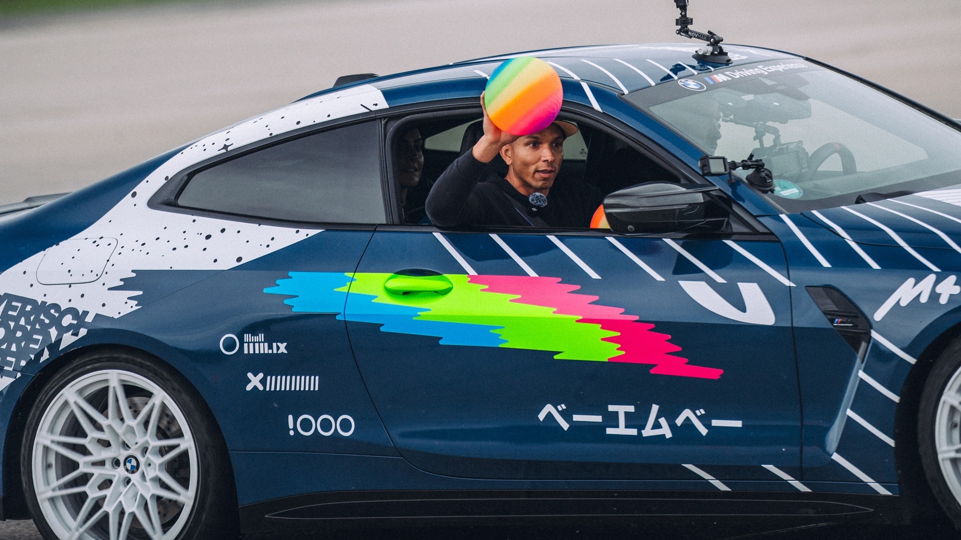 Elias Hountoundji throws a ball from a moving BMW M4 Competition Coupé.