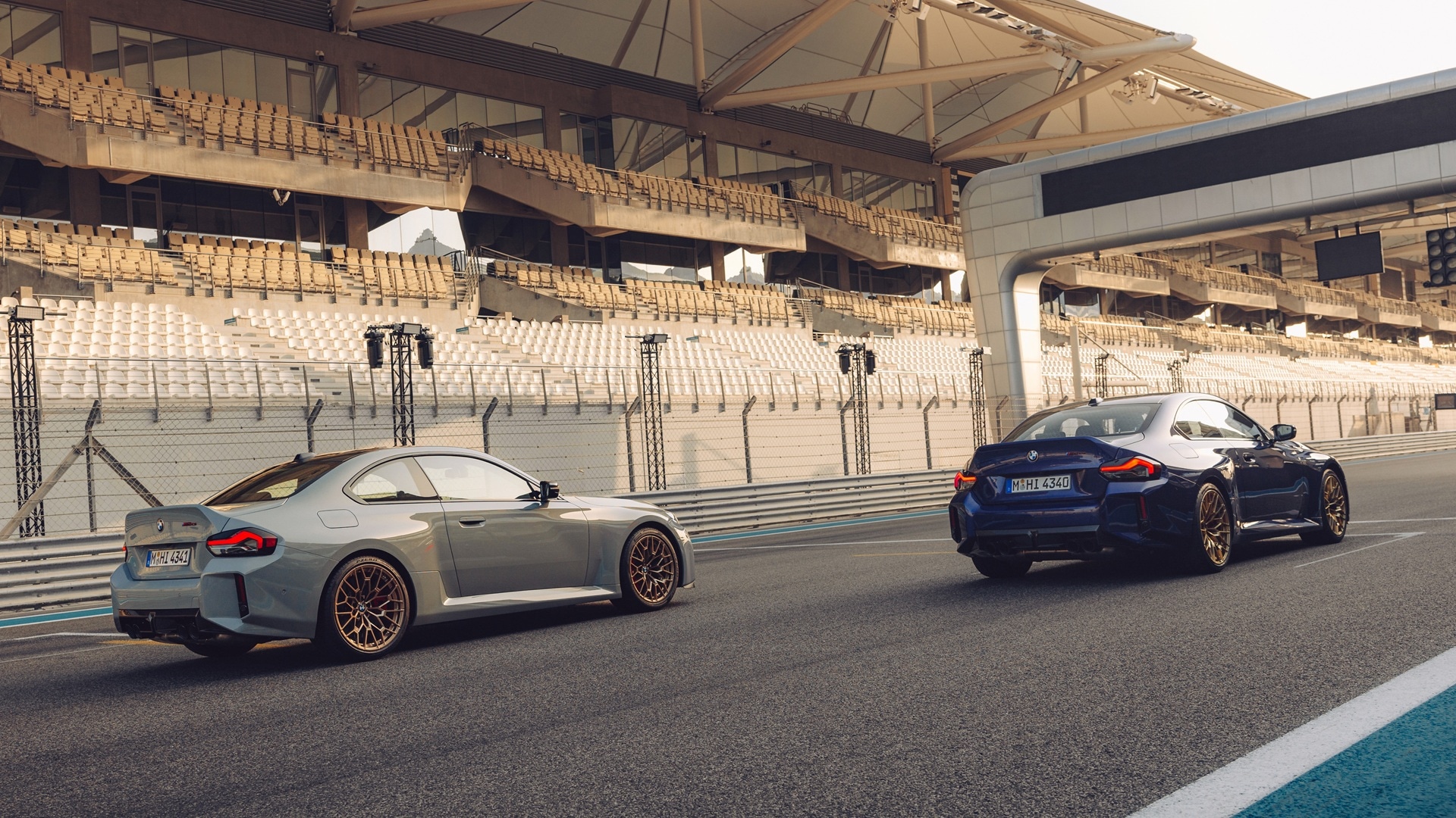 Zwei BMW M2 CS in Velvet Blue metallic und in M Brooklyn Grau metallic auf einer Rennstrecke.