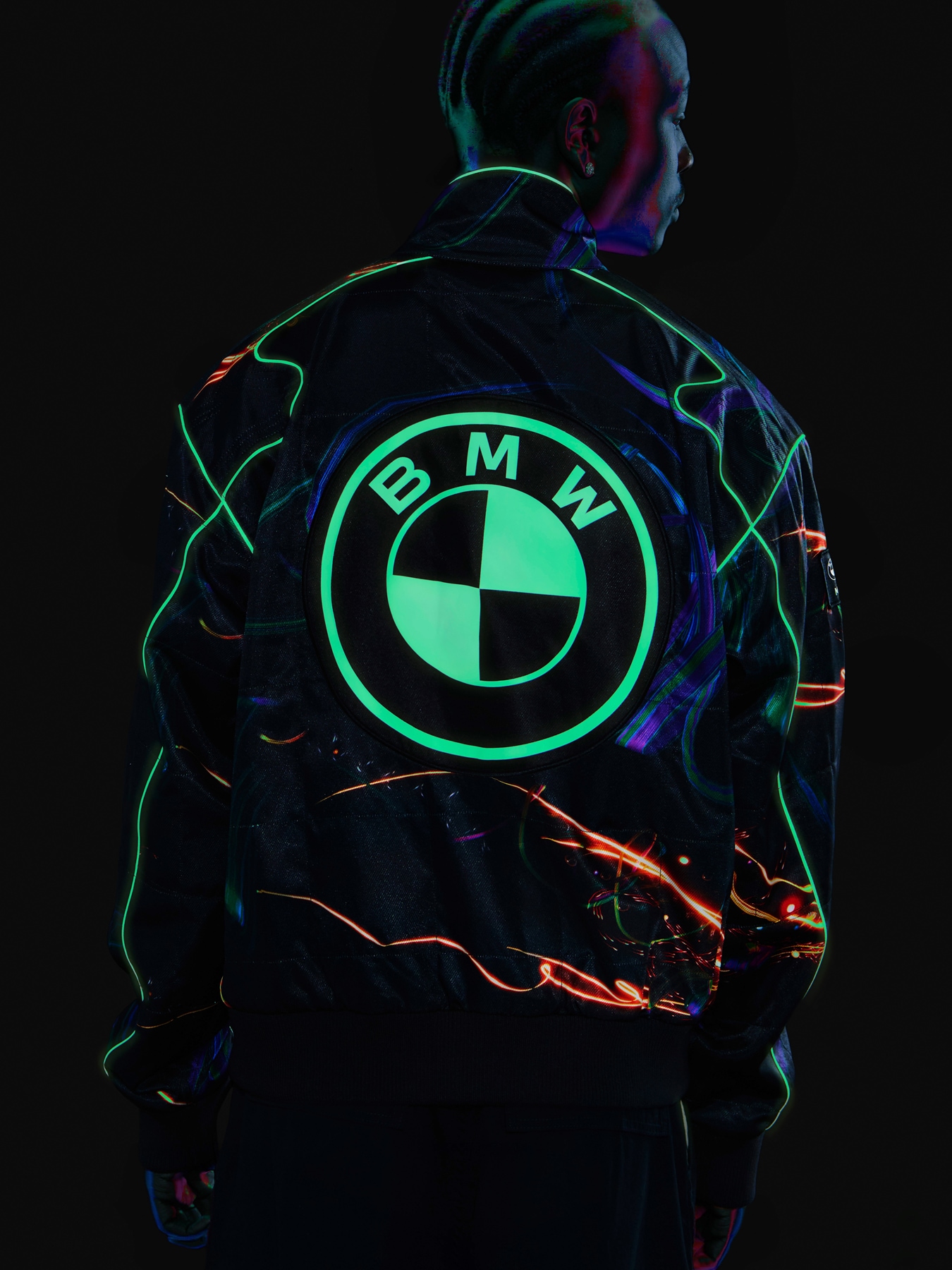 Young man wearing a Cao Fei Caspule racing jacket with a BMW logo that glows in the dark