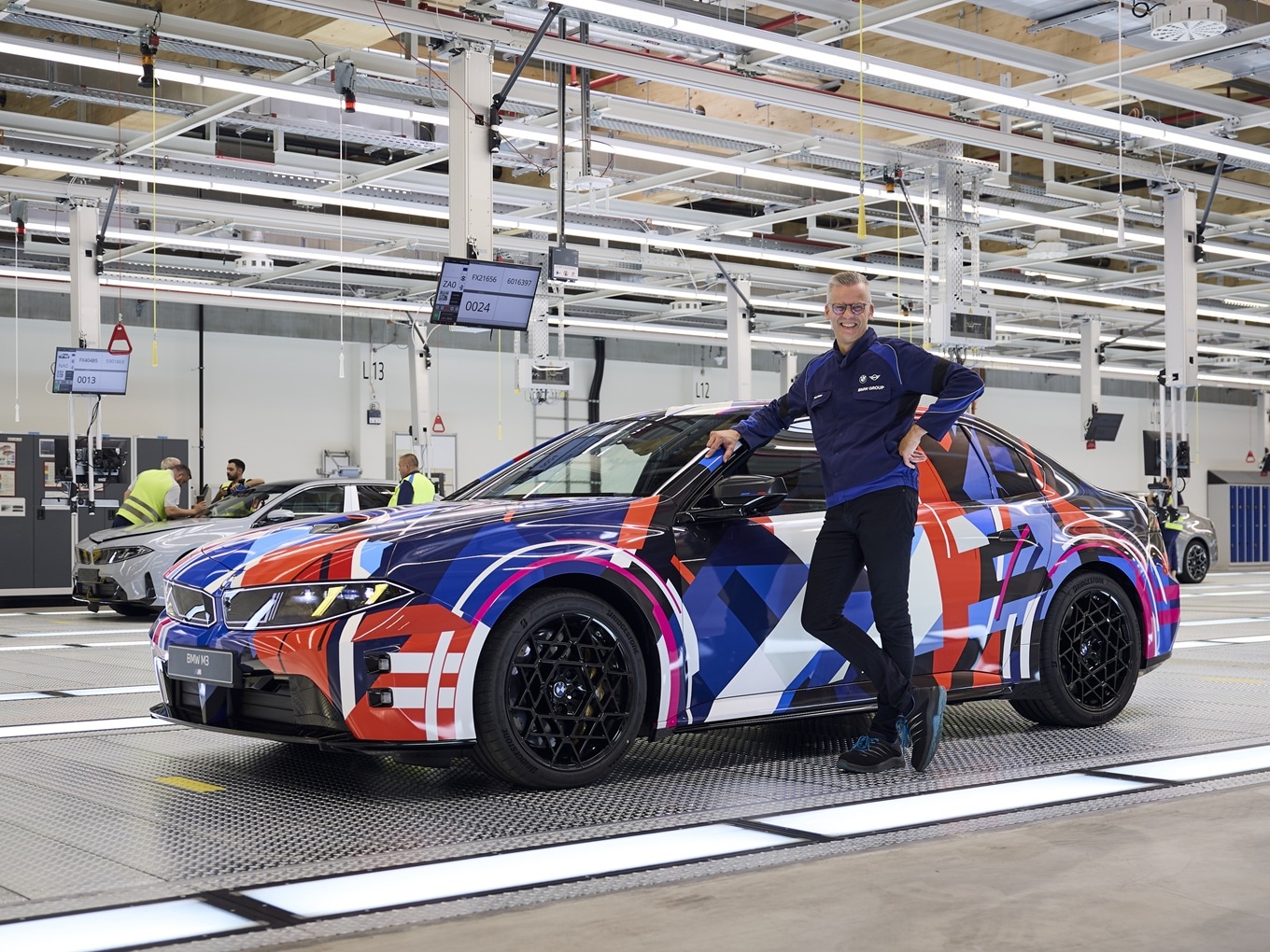Peter Weber, Leiter des BMW Group Werks München steht vor einem einem Vorserienmodell des vollelektrischen BMW M3.