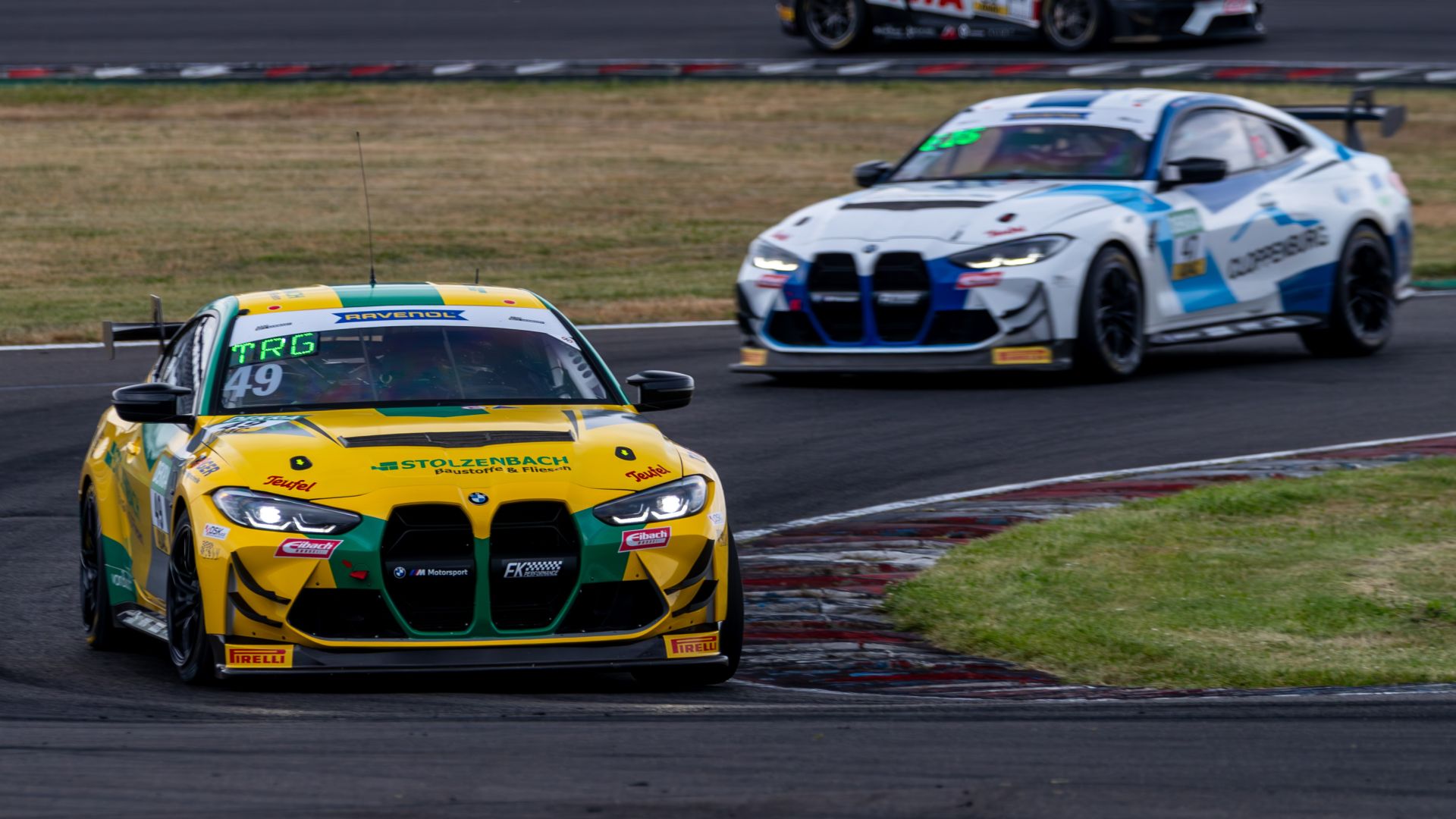Two BMW M4 GT4 EVO on an racetrack. 
