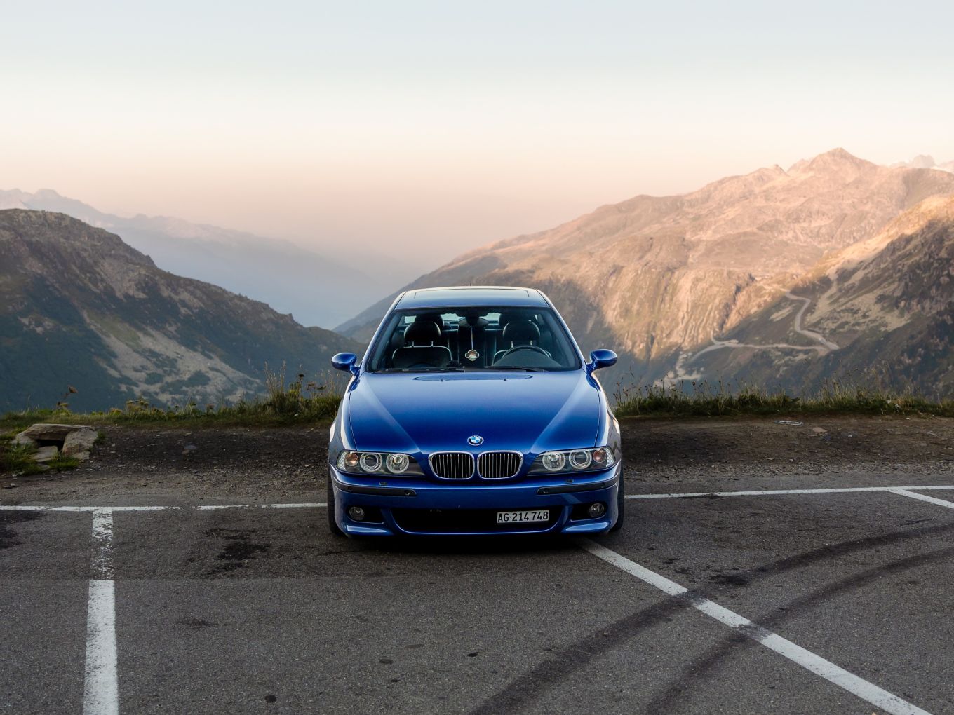 BMW M5 E39 auf einem Parkplatz vor einer Bergkulisse. 