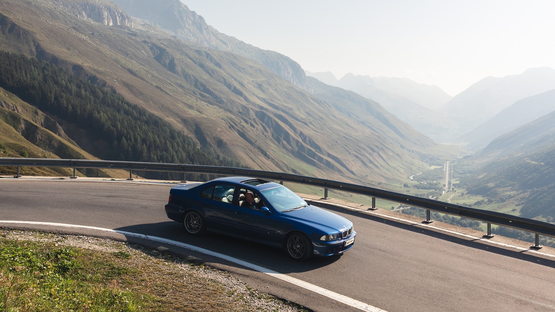 BMW M5 E39 fährt durch die Kehre eines Alpenpasses. 