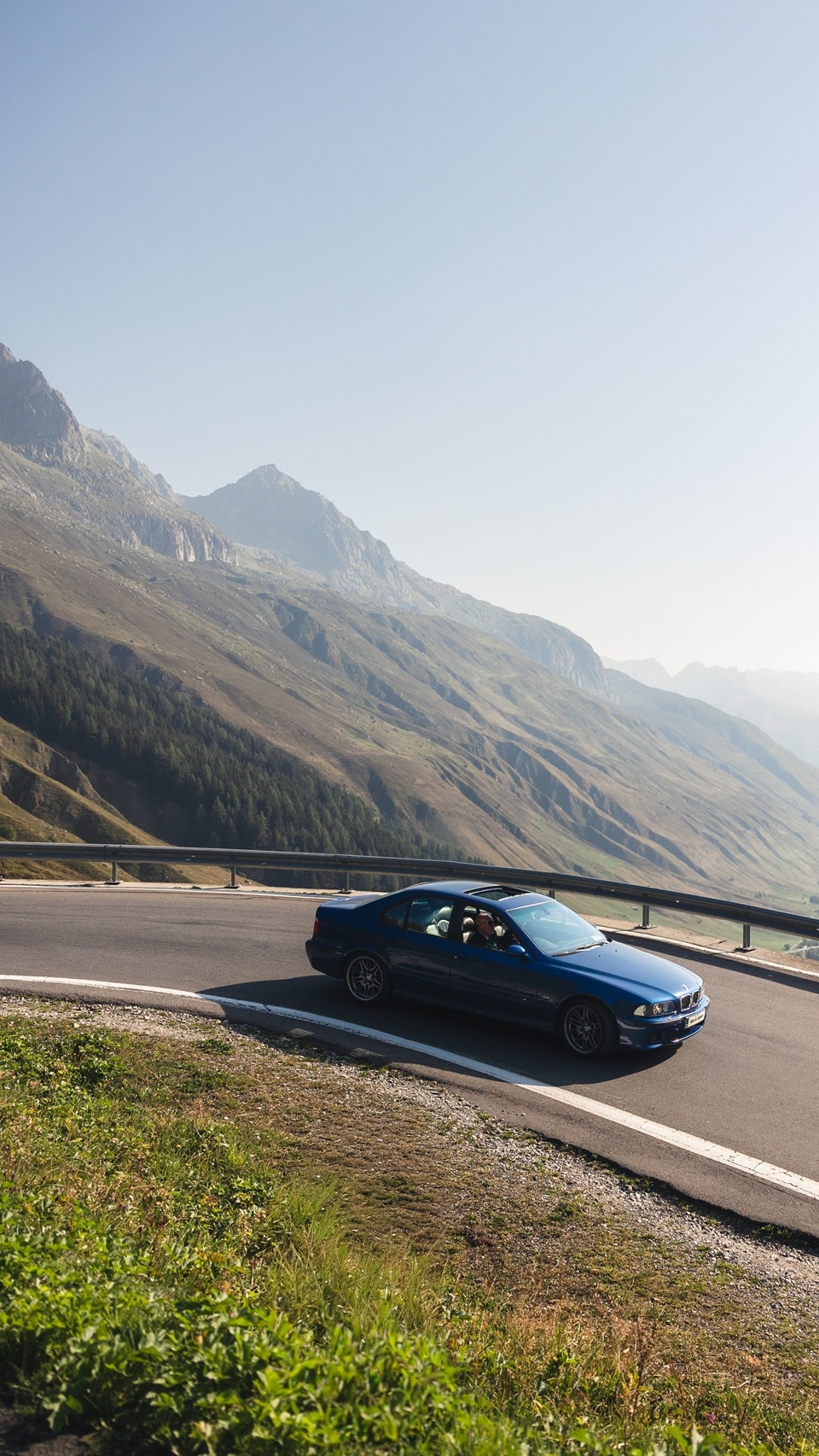 BMW M5 E39 fährt durch die Kehre eines Alpenpasses. 