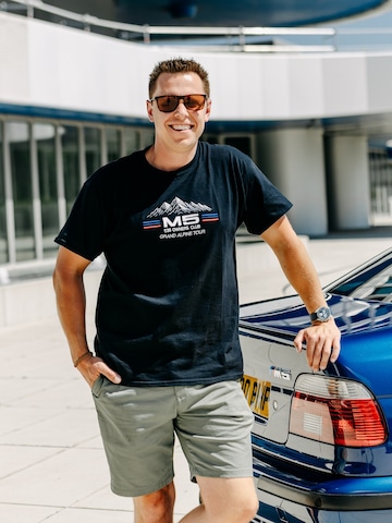 Besitzer lehnt an den Kofferraum seines BMW M5 E39