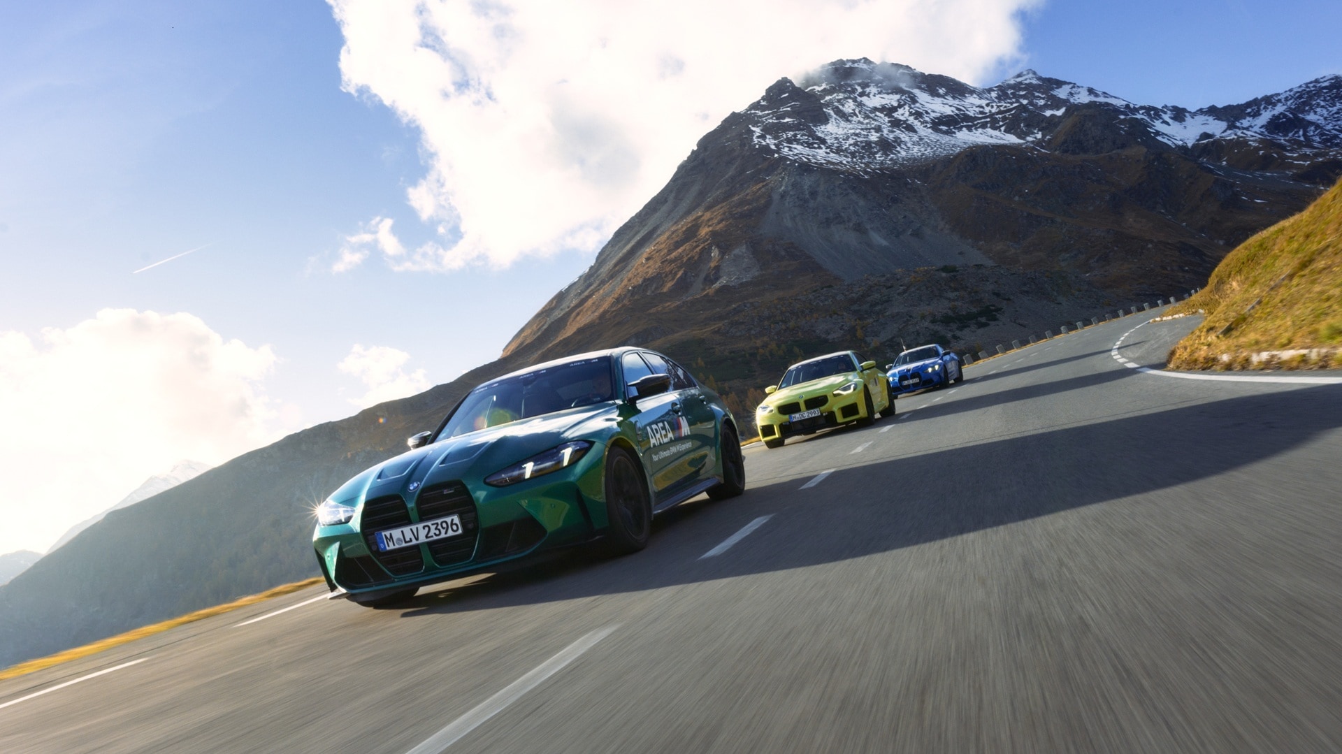 BMW M3 Limousine, BMW M4 Competition Coupé und BMW M2 fahren über einen Gebirgspass.