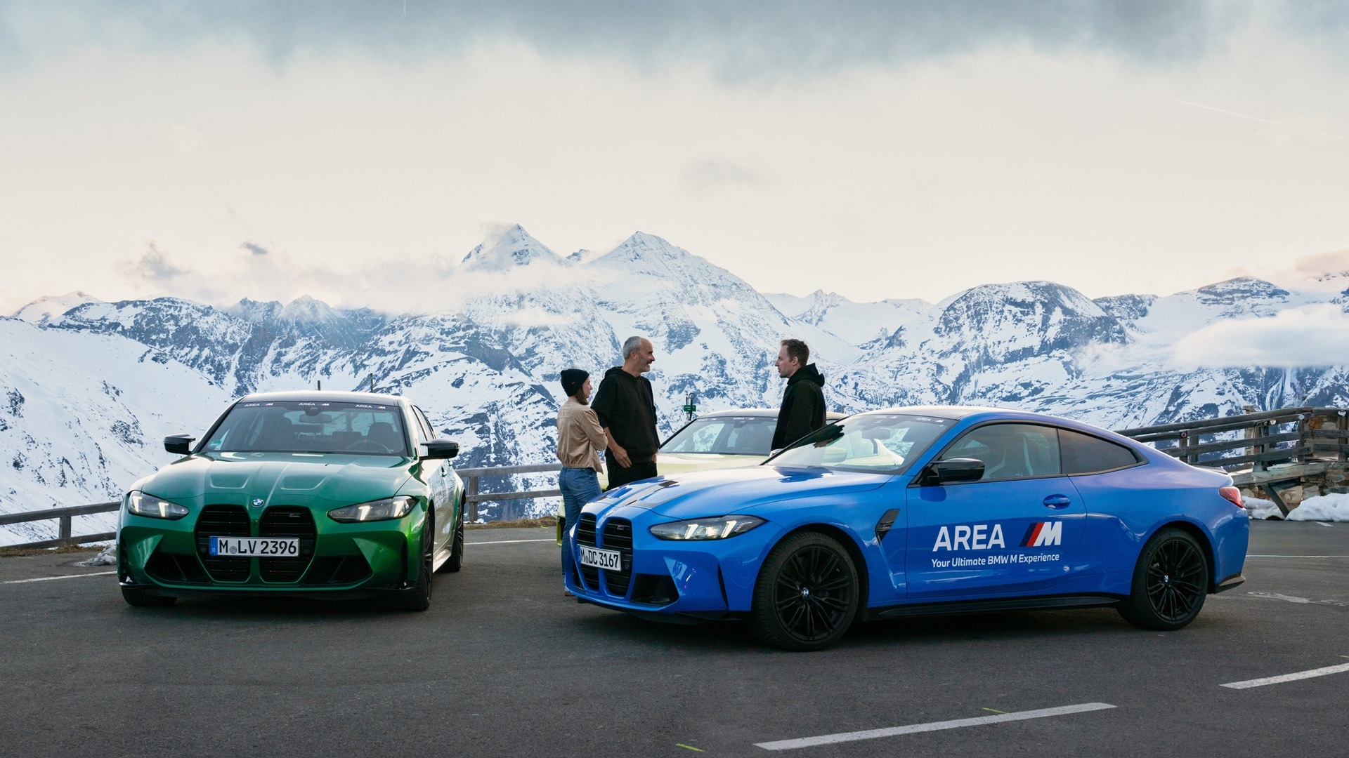Joe Achilles mit Gruppe beim Zwischenstopp mit ihren Fahrzeugen, zwei BMW M4 Competition Coupés und einem BW M2.
