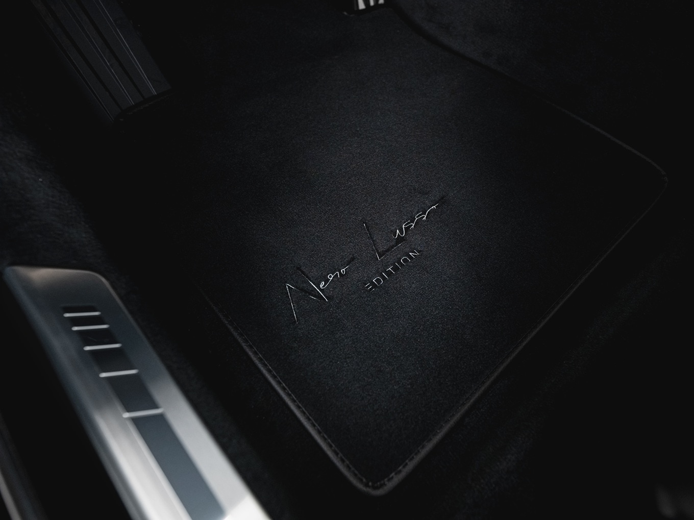 Gaspedal und Fußmatte des BMW 7er Nero Lusso Edition mit Nero Lusso-Editionslogo. 
