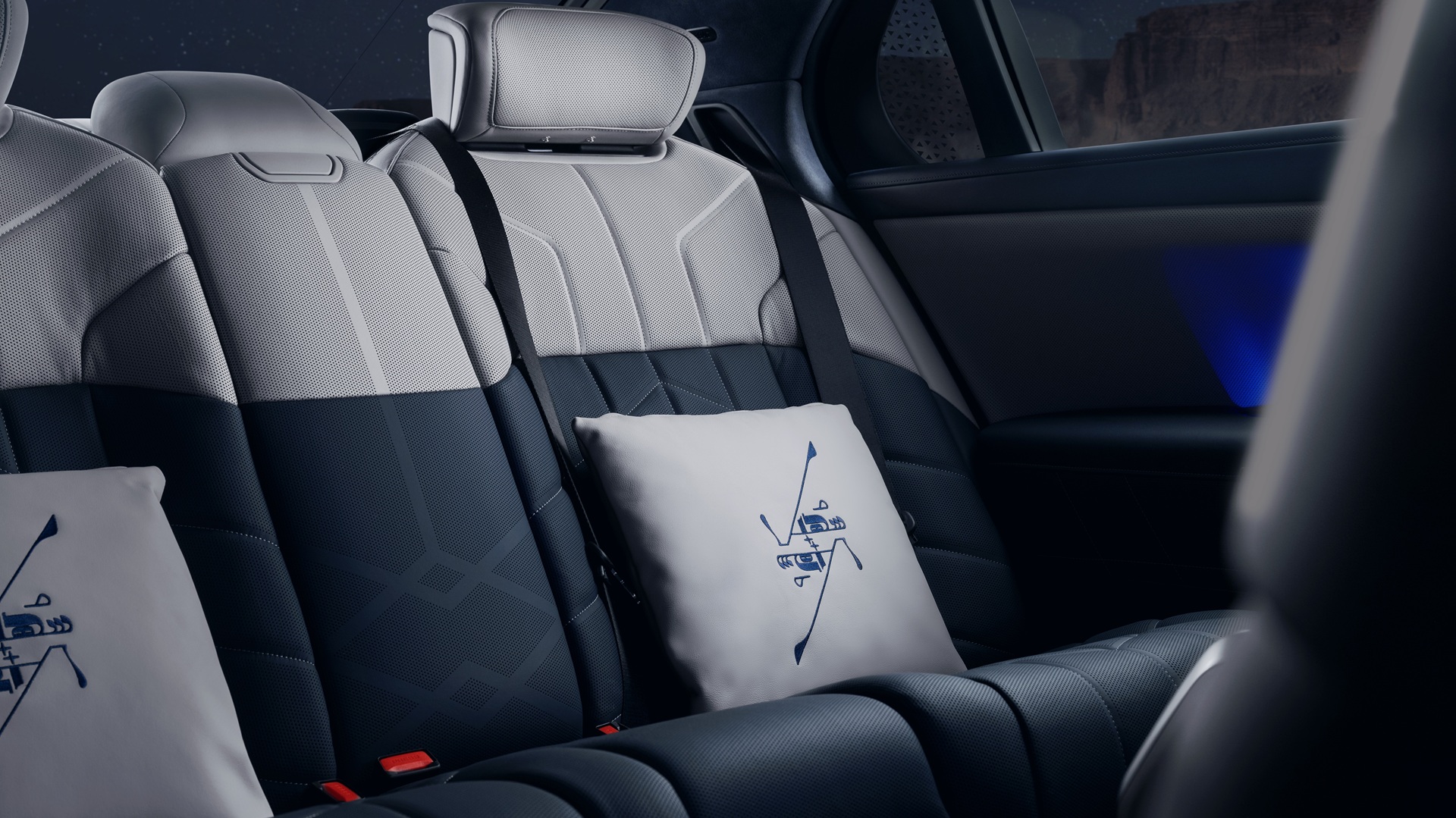 Rear seats of the BMW 7er Suhail Edition upholstered with BMW Individual uphostery Merino Leather in Taupe Grey/Night Blue and cushions with stitchings showing the fixed star Suhail.