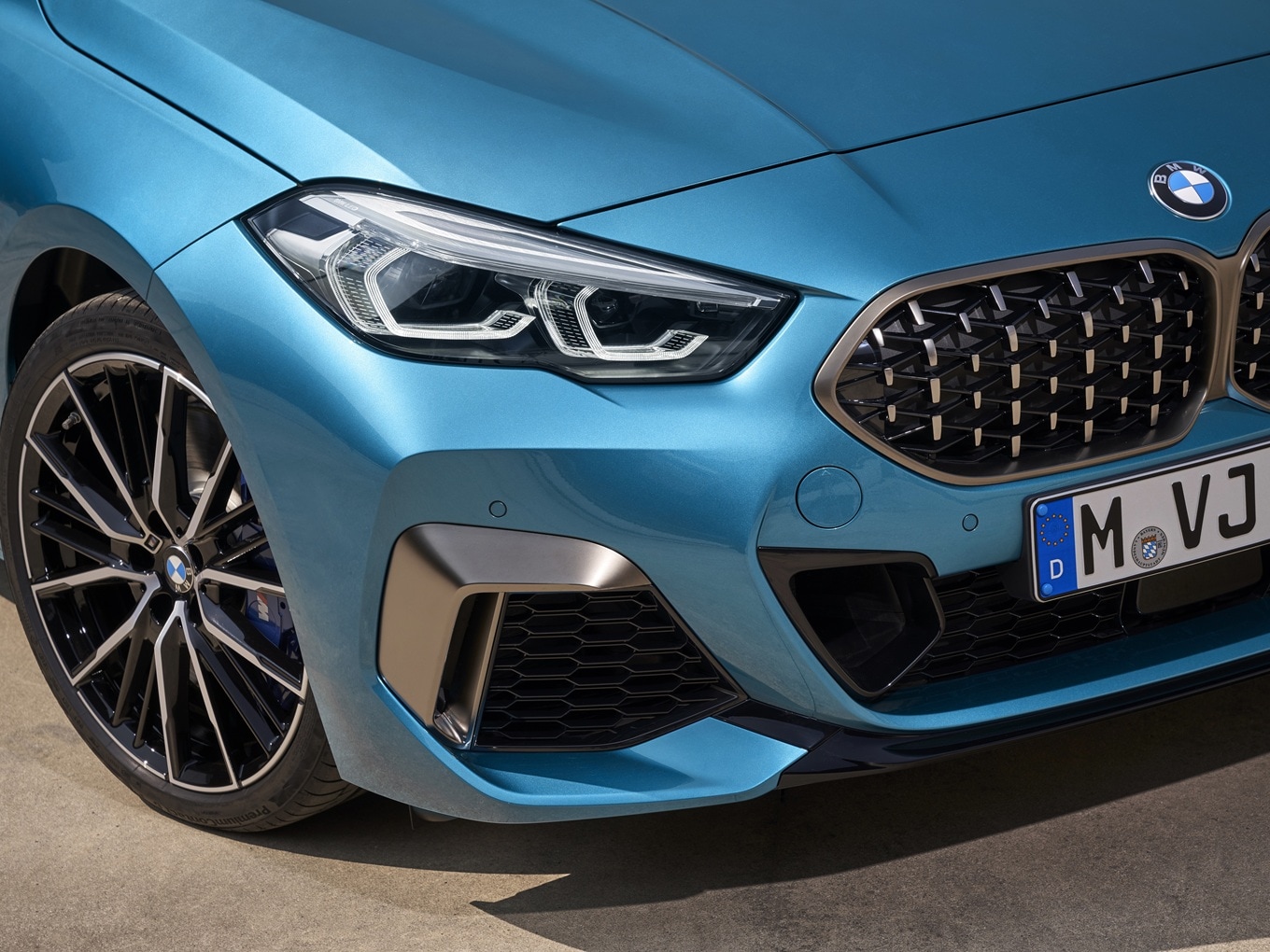 Part of the front of the BMW M235i xDrive Gran Coupé F44 with headlights, air intake in Cerium Grey and 19-inch alloy wheels Styling 552 M.