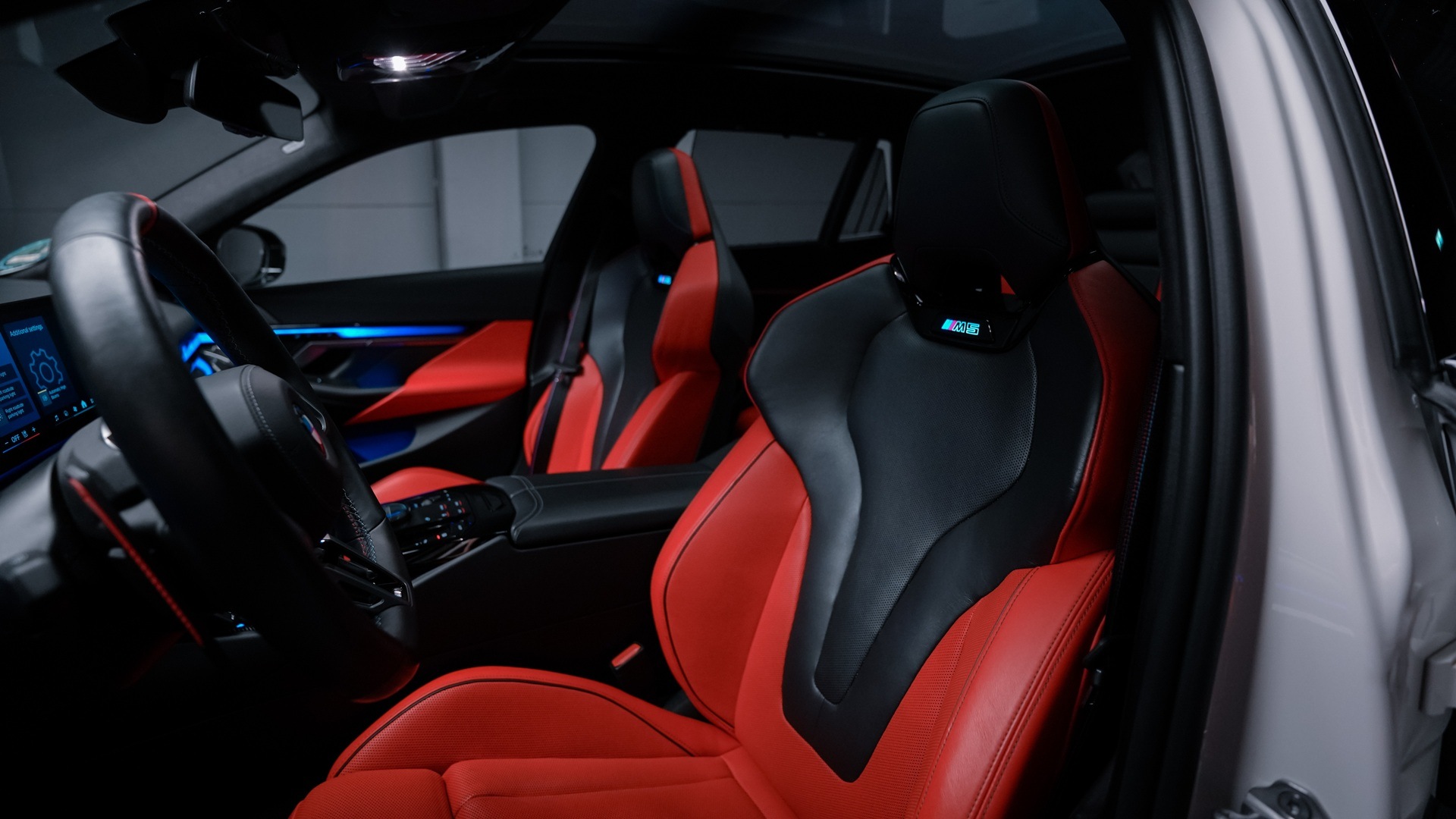 Sitzbezüge in Leder Merino Rot/Schwarz im Innenraum des BMW M5 Touring Polizeiwagens.