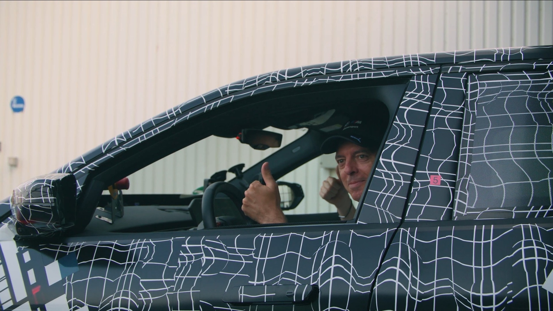 Extremely pleased: Franciscus van Meel, CEO of BMW M GmbH, sitting the pre-production model of the new BMW M3 after his test drive, hand-signalling his contentment.