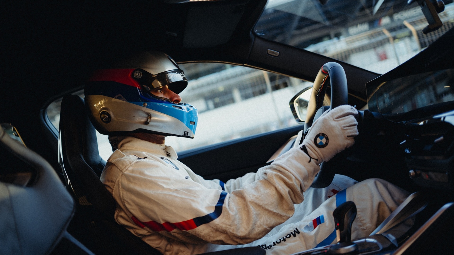 Race car driver in the cockpit of a BMW M4 GT4.