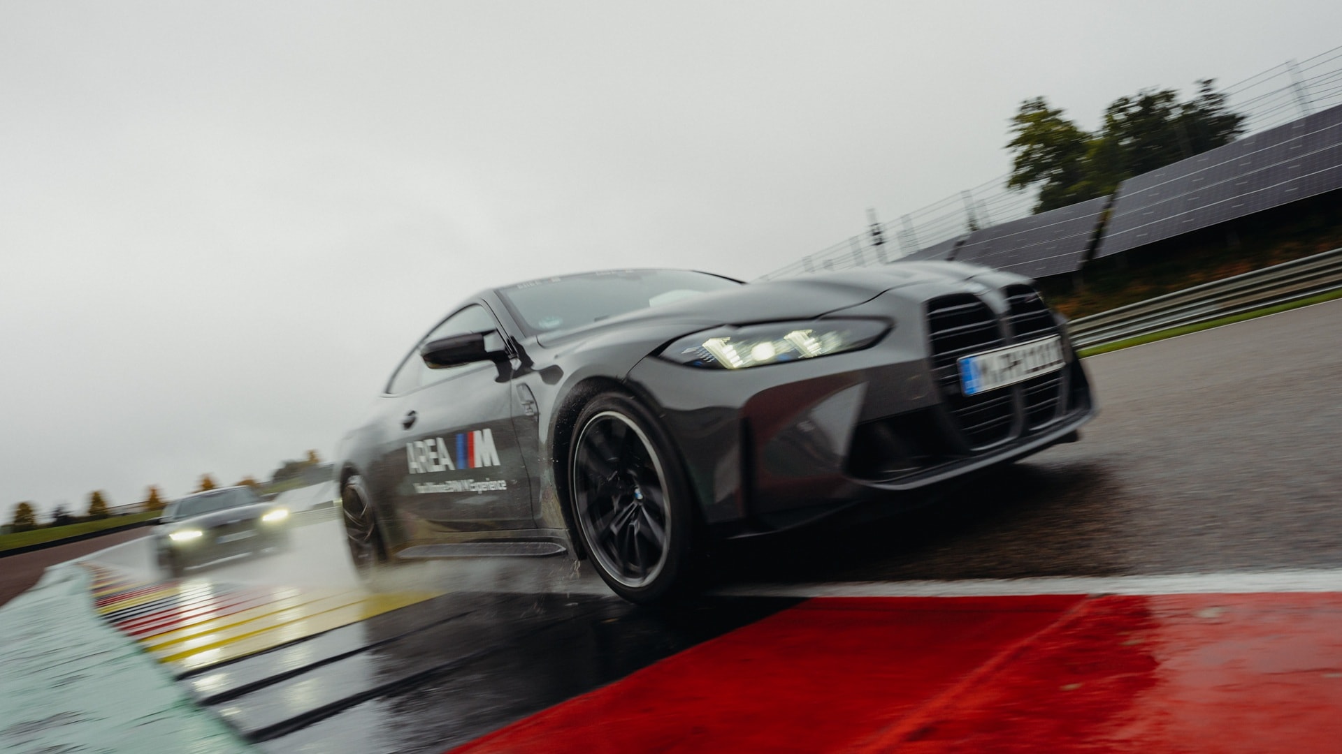 Two BMW M4 taking part in a driver's training session during a heavy rain. 